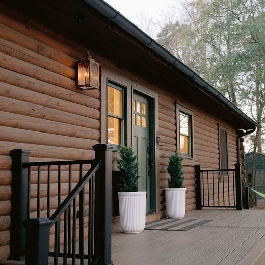 New composite deck with black railings on a log cabin