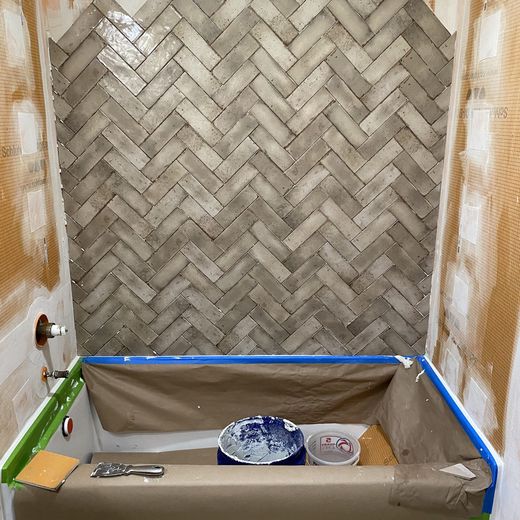 Herringbone tile installation over a protected tub